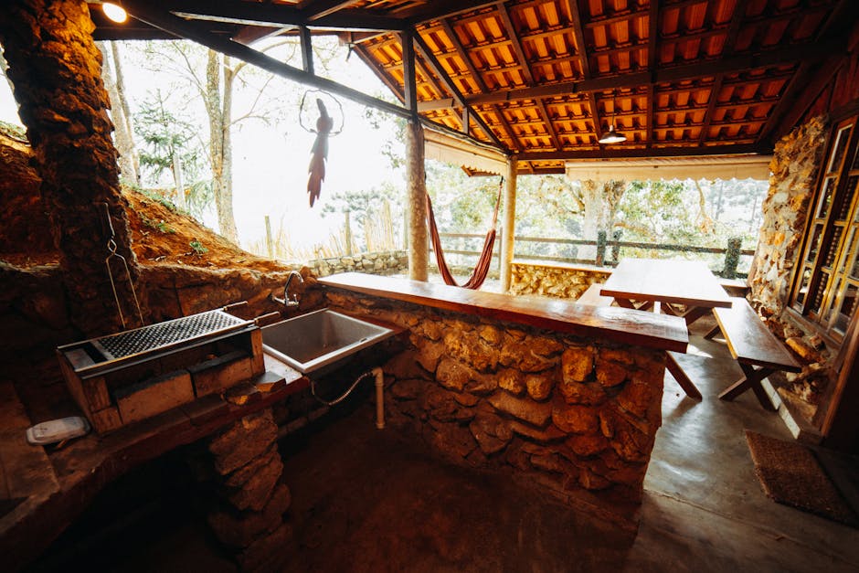 A rustic outdoor kitchen with stone elements and wooden furniture, ideal for countryside relaxation.