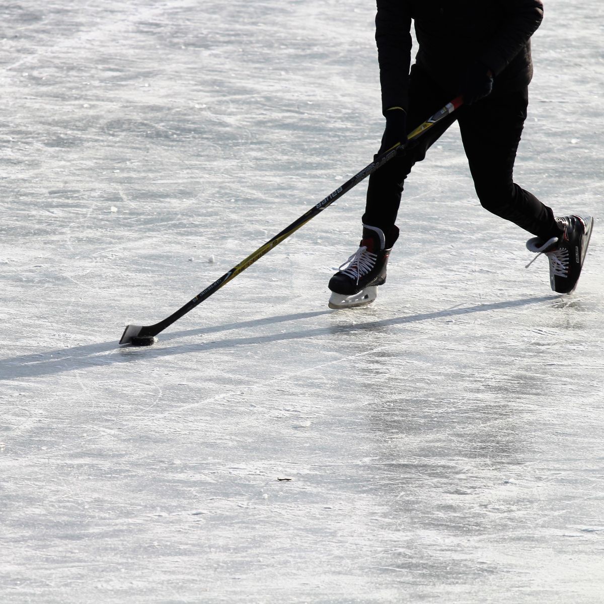 Personne déneigeant une terrasse extérieure en hiver pour un entretien sans rayer les lames