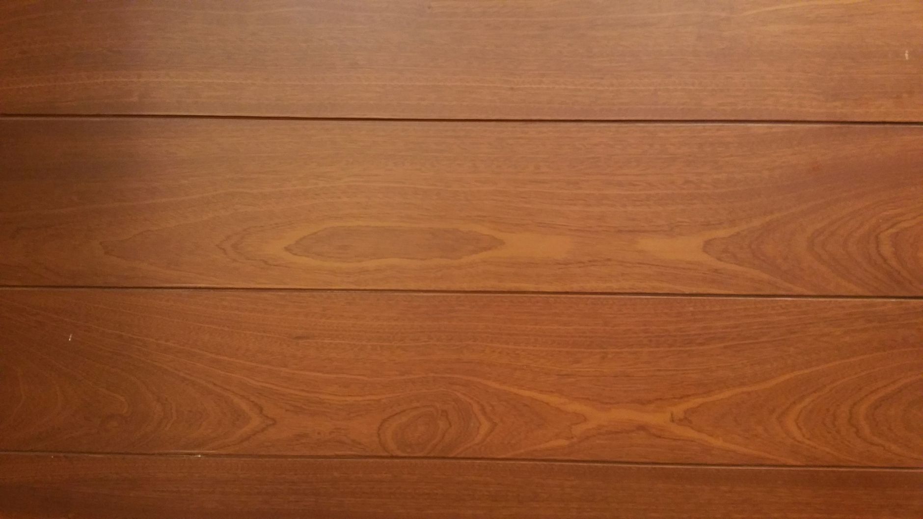 Lames de bois brun à la texture dense et marquée, évoquant une essence exotique classe 4 adaptée à une terrasse résistante au gel