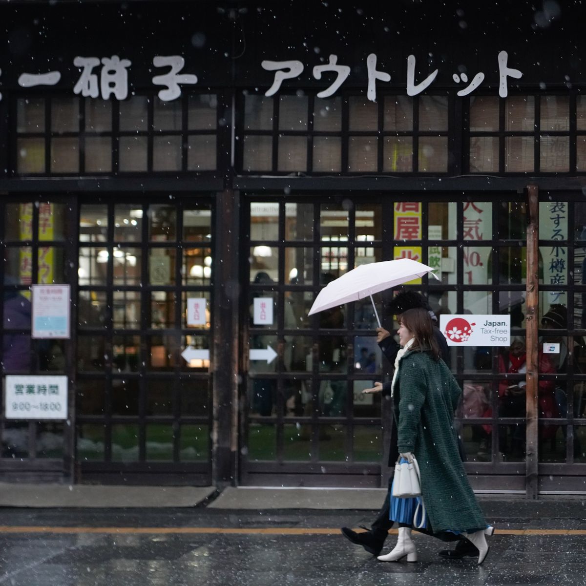 Femme avec parapluie devant un commerce sous la neige illustrant les contraintes hivernales