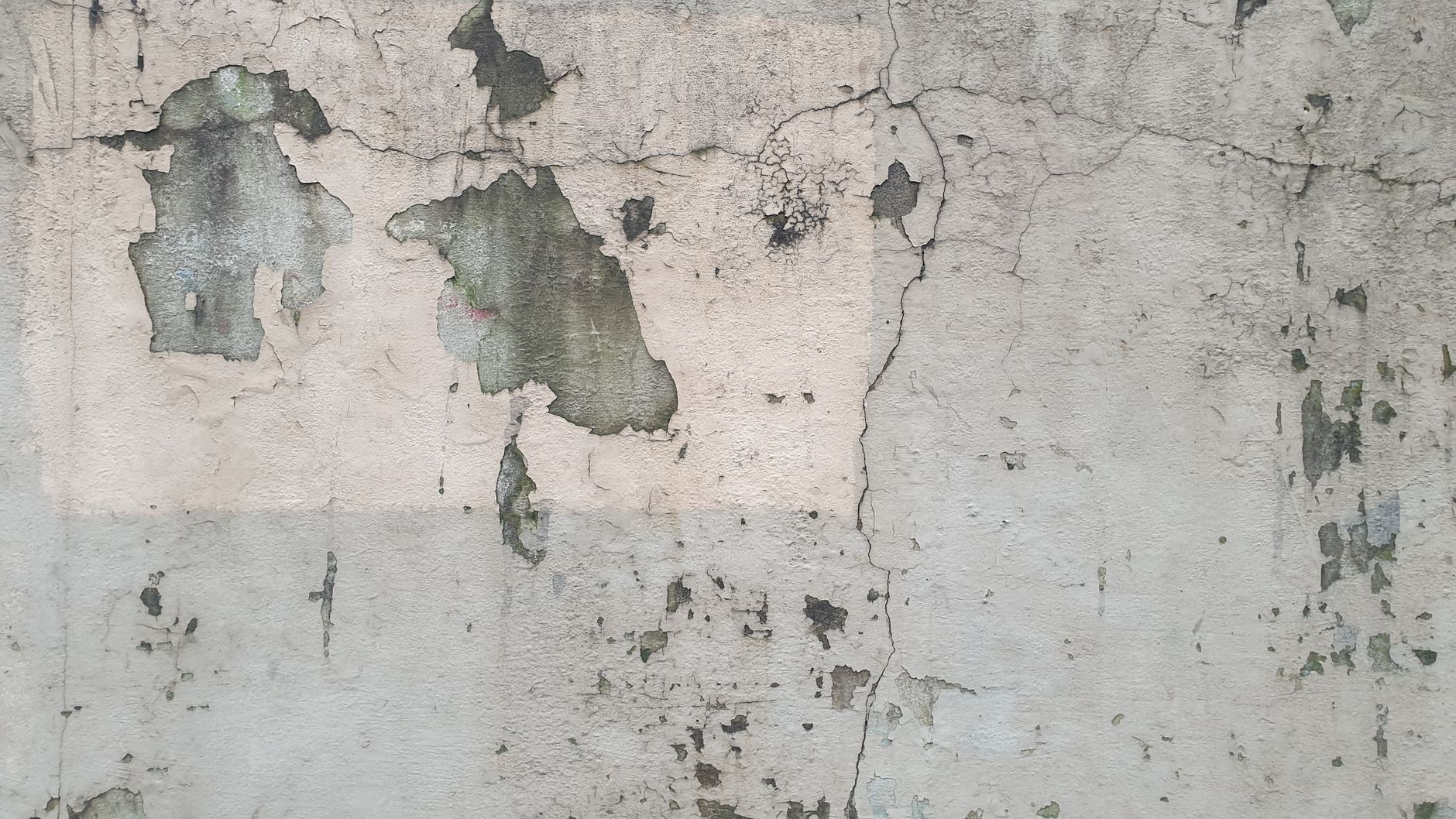 Surface en béton fissurée avec peinture écaillée et textures craquelées, dégradation typique des cycles gel/dégel