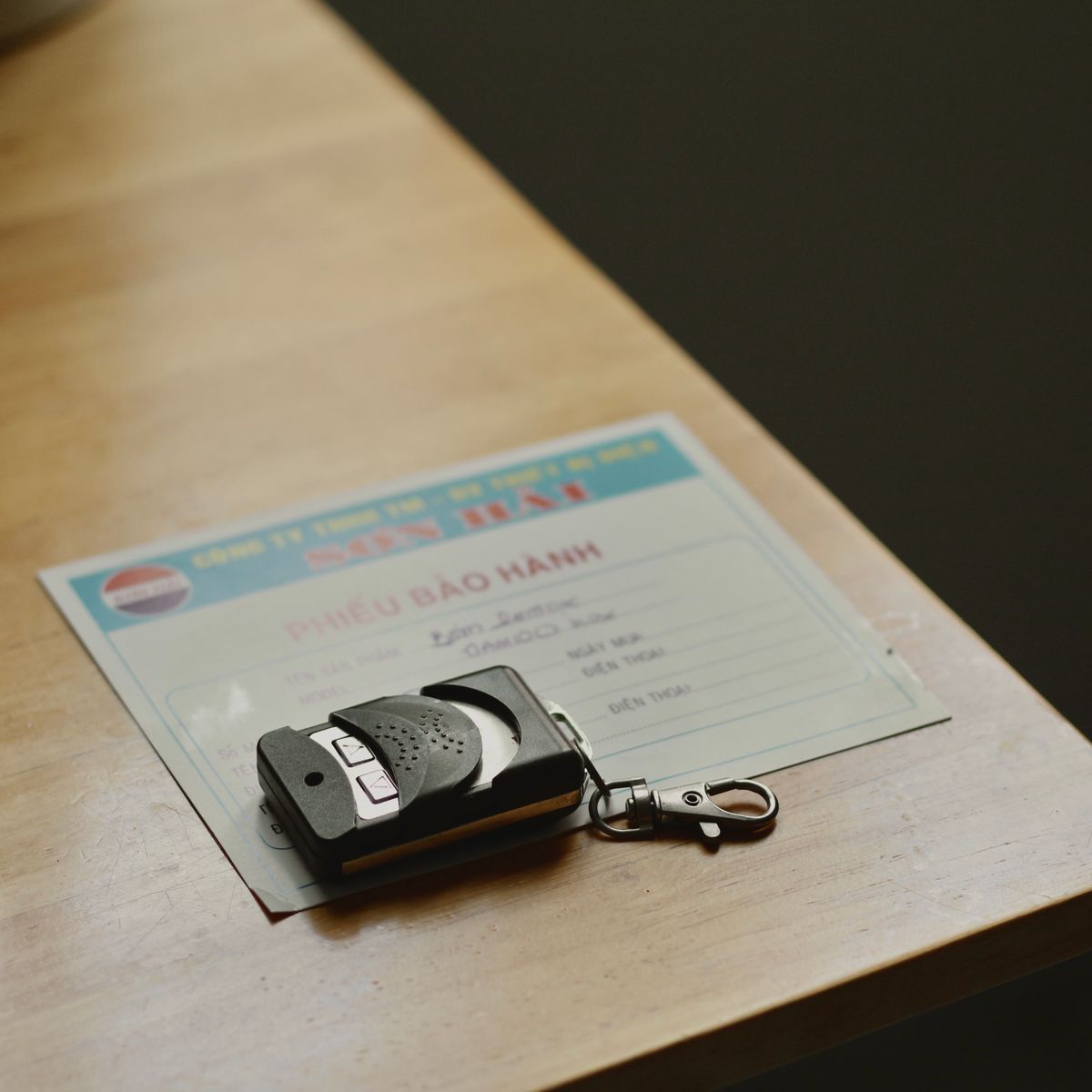 Télécommande posée sur un document de garantie sur une table en bois