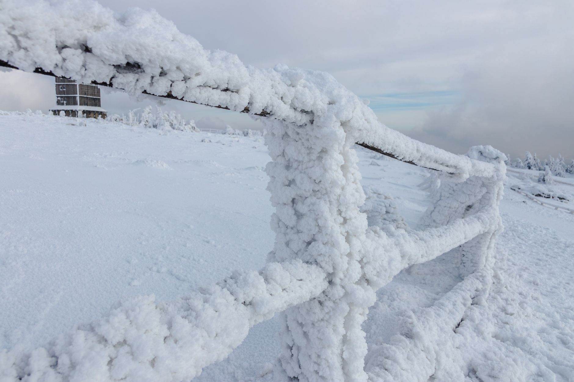 Terrasse et clôture extérieures recouvertes de neige et de gel en hiver, illustrant les contraintes du froid sur les matériaux