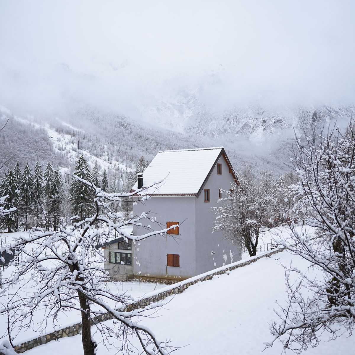 Maison enneigée en montagne montrant la charge de neige qui sollicite les fermetures
