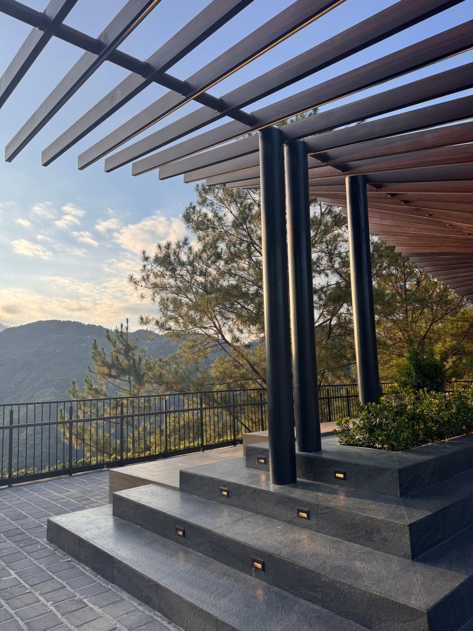 Pergola moderne aux lignes épurées surplombant un paysage de montagne, illustrant le choix de matériaux pour une pergola bioclimatique
