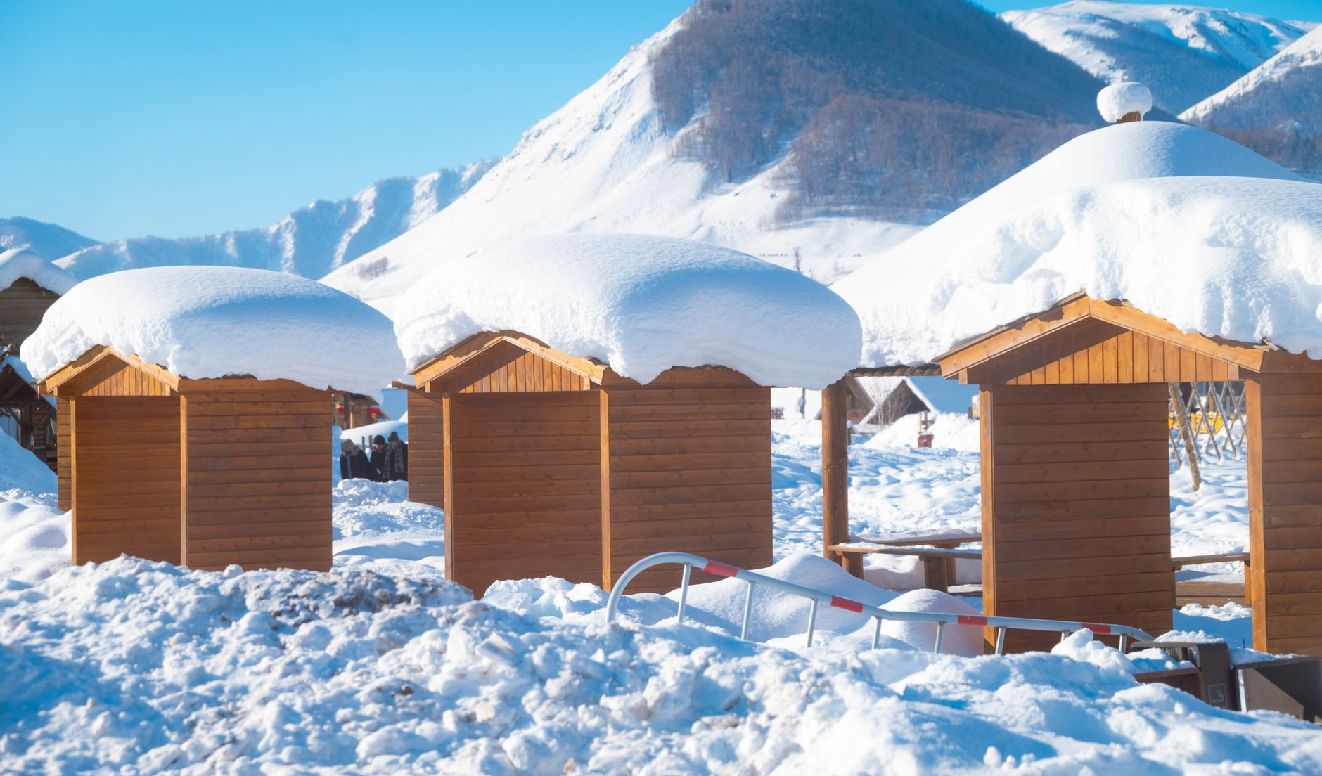 Abri extérieur supportant une importante accumulation de neige en montagne, illustrant le surcoût de dimensionnement lié à la charge de neige