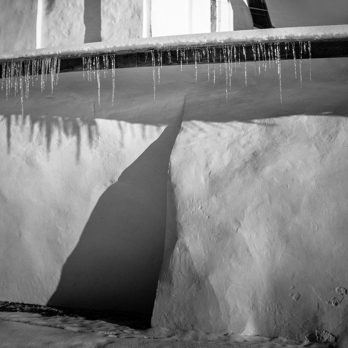 Stalactites de glace suspendues à un mur, signe du gel et de la neige humide